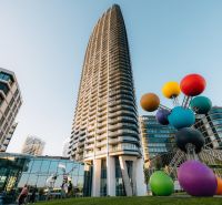EUROVEA CITY - Výstavba bytov na Pribinovej v Bratislave - Ružinove s farebnou sochou v popredí.