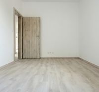 Novostavba pri jazere - 4 izbový rodinný dom v štandarde v obci Selice - Izba s podlahou s dreveným dekorom a drevenými dverami v rodinnom dome.