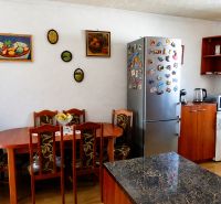 Predaj, 2 - izbový byt, Žiar nad Hronom - Kuchyňa v 2-izbovom byte so stolom, chladničkou a dekoráciami na stene.