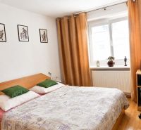 Predaj, 2 - izbový byt, Žiar nad Hronom - Spálňa v 2-izbovom byte s posteľou, pracovným stolom a podlahou s dreveným dekorom.