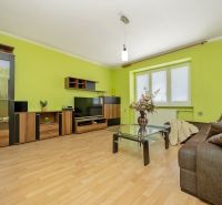 Veľký klimatizovaný 2izbový byt centrum I, Nové Mesto nad Váhom - Obývacia izba s podlahou s dreveným dekorom, zelenými stenami a pohovkou v 2-izbovom byte.