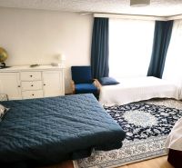 Priestranný 6-izbový rodinný dom v srdci Vysokej nad Kysucou – komfort - Spálňa v rodinnom dome s posteľou, kobercom, komodou a modrým kreslom.