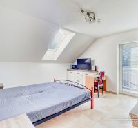REZERVOVANÉ 5-izbový rodinný dom Hrnčiarovce - Spálňa v podkroví rodinného domu s jednoduchým nábytkom a strešným oknom.