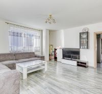 REZERVOVANÉ 5-izbový rodinný dom Hrnčiarovce - Obývačka v rodinnom dome s rohovo umiestnenou pohovkou a podlahou s dreveným dekorom.