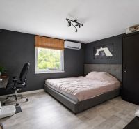 Ponúkame na predaj rodinný dom s veľkým pozemkom v obci Trnávka - Spálňa s posteľou, skriňou a pracovným stolom, podlaha s dreveným dekorom.