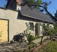 NA PREDAJ celoročná chata – Sekule (Šutrovňa), tiché prostredie - Pred chatou na ulici Sekule v Sekuliach sú stromy a záhradný nábytok.