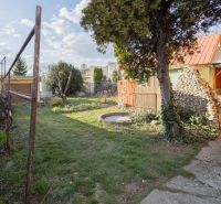 Predaj rodinného domu Piešťany - Záhrada rodinného domu na Mlynskej ulici v Piešťanoch s trávnikom a stromami.