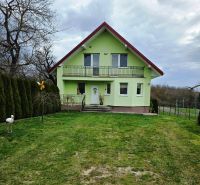 Poschodový rodinný dom v  obci Klokočov okr. Michalovce - Zelený rodinný dom v Klokočove s verandou a upravenou záhradou.