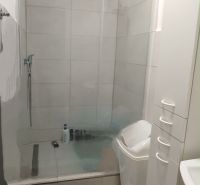 HZ27 -Na predaj 2-izbový kompletne zrekonštruovaný byt v Komárne - Kúpeľňa v 2-izbovom byte s priestranným sprchovacím kútom a bielym nábytkom.