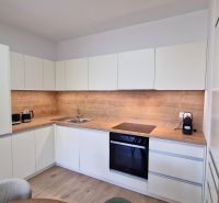 Exkluzívne 2 izbový byt POPRAD Karpatská, s garaž. st., balkón, 58 m2 - Kuchyňa v 2-izbovom byte s dreveným dekorom a zabudovanými spotrebičmi.