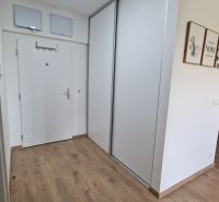 Exkluzívne 2 izbový byt POPRAD Karpatská, s garaž. st., balkón, 58 m2 - Interiér 2-izbového bytu s podlahou s dreveným dekorom, bielymi dverami a jedálenským kútom.