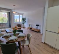 Exkluzívne 2 izbový byt POPRAD Karpatská, s garaž. st., balkón, 58 m2 - Obývacia izba s kuchynským kútom v 2-izbovom byte s podlahou s dreveným dekorom.