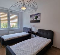 Exkluzívne 2 izbový byt POPRAD Karpatská, s garaž. st., balkón, 58 m2 - Spálňa v 2-izbovom byte s dvomi posteľami a podlahou s dreveným dekorom.