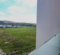 Na predaj 4iz. byt na Banke pri Piešťanoch - Výhľad z 4-izbového bytu na Moravanskej ulici v Banke, zelené polia a krajina.