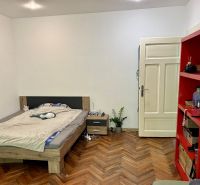 – PRENAJOM – 2 IZBOVÝ – MURGAŠOVA – STARE MESTO  - Spálňa v 2-izbovom byte s posteľou, červenou policou a podlahou s dreveným dekorom.