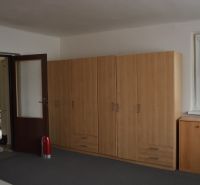 Domček na chalupárčenie s veľkým pozemkom s termál kúpaliskom v obci! - Miestnosť v rodinnom dome s hnedými skriňami, oknom a dverami.