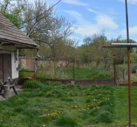 Domček na chalupárčenie s veľkým pozemkom s termál kúpaliskom v obci! - Rodinný dom v Horných Salibách s trávnikom a záhradou, okolo ktorého je plot.