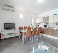 Brač(HR) - Apartmány v 1. rade u mora !!! - Svetlá kuchyňa s jedálenským stolom a televízorom v rekreačnom apartmáne.