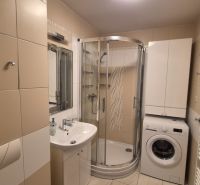 Investičný apartmán Vysoké Tatry - Stará Lesná s balkónom a park.miest - Kúpeľňa s umývadlom, sprchovým kútom a práčkou v rekreačnom apartmáne.