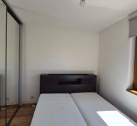 Investičný apartmán Vysoké Tatry - Stará Lesná s balkónom a park.miest - Spálňa v Rekreačnom apartmáne s podlahou s dreveným dekorom a šatníkovou skriňou.