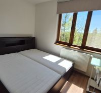 Investičný apartmán Vysoké Tatry - Stará Lesná s balkónom a park.miest - Spálňa s manželskou posteľou, podlahou s dreveným dekorom a oknom v Rekreačnom apartmáne.