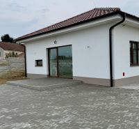 * novostavba moderného 4i domu, Vlčany, centrum - Rodinný dom na Hlavnej ulici vo Vlčanoch s bielou fasádou a dláždeným nádvorím.