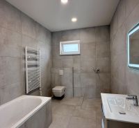 * novostavba moderného 4i domu, Vlčany, centrum - Kúpeľňa rodinného domu s vaňou, sprchou a osvetleným zrkadlom.
