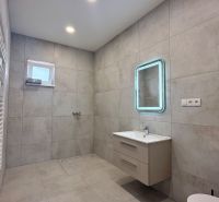 * novostavba moderného 3i domu, Vlčany, centrum - Kúpeľňa v rodinnom dome s moderným umývadlom, zrkadlom a rebríkovým radiátorom.