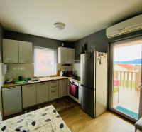 Brač(HR)–Apartmán s výhľadom na more - Kuchyňa rekreačného apartmánu s podlahou s dreveným dekorom a svetlým nábytkom.