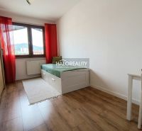 Predaj, trojizbový byt Revúca, Panoramatický výhľad ... - Svetlá izba s posteľou, stolom a podlahou s dreveným dekorom v 3-izbovom byte.
