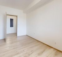 2 izbový prerobený byt v Trenčíne Pred poľom s balkónom - Izba s bielymi stenami a podlahou s dreveným dekorom v 2-izbovom byte.