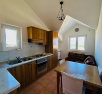 Brač(HR)–Zariadený apartmán 56m2 s výhľadom na more - Kuchyňa s dreveným dekorom, jedálenským stolom a pohovkou v rekreačnom apartmáne.