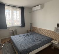Prenájom 2i-byt s lodžiou s krásnym výhľadom na Račianskej ulici - Spálňa v 2-izbovom byte s kobercami na podlahe s dreveným dekorom.