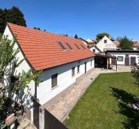 3-izbový dom s nádherným výhľadom a historickou vínnou pivnicou, Berg - Rodinný dom v meste Berg s červenou strechou a zeleným trávnikom.