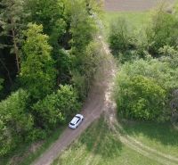 Pozemok vhodný na chov včiel Streženice- 874 m2 - Auto na lesnej ceste medzi zelenou vegetáciou v Rekreačných pozemkoch v Streženiciach.