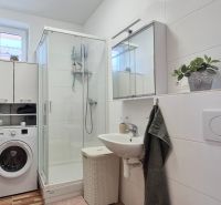 ŠTÝLOVÝ 3-IZBOVÝ BUNGALOV V KÚPEĽNÝCH DUDINCIACH - Kúpeľňa v rodinnom dome s práčkou, sprchovacím kútom a bielym umývadlom.