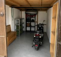 Predám murovanú garáž v Nových Zámkoch - Garáže s motocyklom, dreveným stropom a policami na uskladnenie.