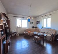 Dobré Reality ponúkajú rodinný dom s veľkou záhradou v obci Svinná  - Obývačka v rodinnom dome s tmavou podlahou a sedacou súpravou.