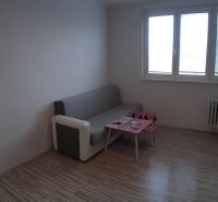 Na prenájom 2-izbový byt - Nové Zámky - Obývacia izba v 2-izbovom byte s gaučom a stolíkom, podlaha s dreveným dekorom.