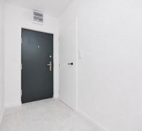 3 IZBOVÝ- NOVOZREKONŠTRUOVANÝ BYT- NA PREDAJ-UL. POKROKU-KE-ZÁPAD - Vstupná chodba so sivými dverami a bielymi stenami v 3-izbovom byte.
