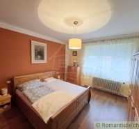 Vymením dom s veľkou záhradou v obci Mýtna za 2 i byt v Lučenci - Spálňa v rodinnom dome s dreveným dekorom, posteľou a nábytkom v teplých farbách.