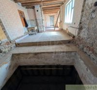 SOBOTIŠTE – VIDIECKY DOM PO ZÁSADNEJ REKONŠTRUKCII ( PRIPRAVENÝ NA DOK - Interiér rodinného domu v rekonštrukcii s odkrytými múrmi a schodiskom.