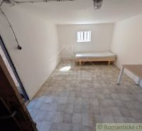 SOBOTIŠTE – VIDIECKY DOM PO ZÁSADNEJ REKONŠTRUKCII ( PRIPRAVENÝ NA DOK - Izba v rodinnom dome s posteľou, stolom a oknom, svetlé steny.