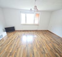 Rezervované: 3 izbový TEHLOVÝ byt 83m2 s loggiou - Uľanka  - Priestranná obývačka s podlahou s dreveným dekorom a veľkým oknom v 3-izbovom byte.