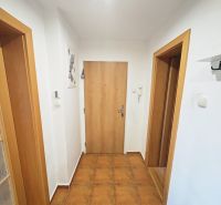 Rezervované: 3 izbový TEHLOVÝ byt 83m2 s loggiou - Uľanka  - Chodba v 3-izbovom byte s keramickou dlažbou, bielymi stenami a drevenými dverami.
