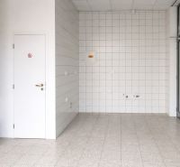 *Prenájom obchodného priestoru s výkladom, 26,3 m² – Račianske mýto* - Obchodné priestory so svetlou podlahou, bielymi dlaždicami a dreveným dekorom na stene.