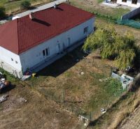 NA PREDAJ 3-IZBOVÝ RD (ČASŤ DVOJDOMU), ZEMIANSKA OLČA - Rodinný dom v Zemianskej Olči s červenou strechou, trávnikom a lodnými prívesmi na dvore.