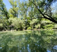 Celoročne obývateľná chata v Gabčíkove na 150 m² pozemku pri Dunaji - Pokojná vodná plocha so stromami odrážajúcimi sa na hladine pri chate v Gabčíkove.