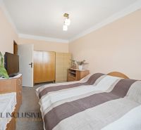 Na predaj 2-izb. byt s pivnicou, Kolárovo - Spálňa v 2-izbovom byte s nábytkom, televíziou a posteľou s pruhovanou dekou.