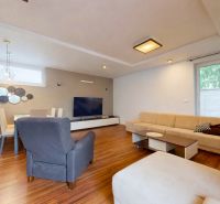 5-izbový dom 170m² + pozemok 529m² | Podunajské Biskupice - Obývacia izba v rodinnom dome s pohovkou, kreslom, jedálenským stolom a podlahou s dreveným dekorom.